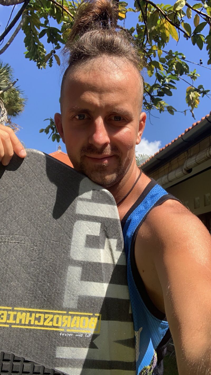 Nikita holding a foilboard at the beach in Bali