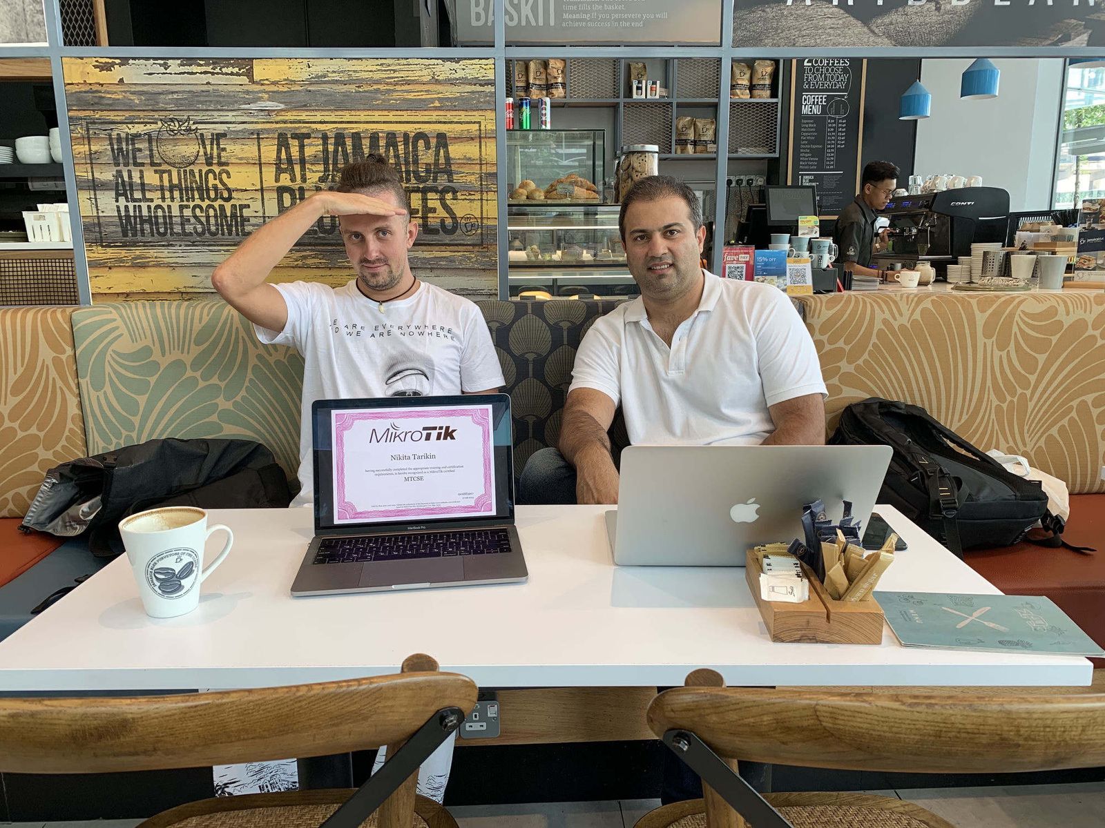 Nikita Tarikin and the MikroTik trainer who examined him, Kuala Lumpur 2019, the MTCSE certificate shown on a laptop.