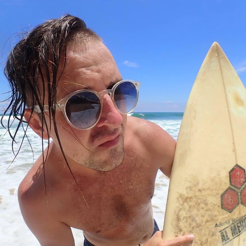 Nikita on the beach with a surfboard in Bali
